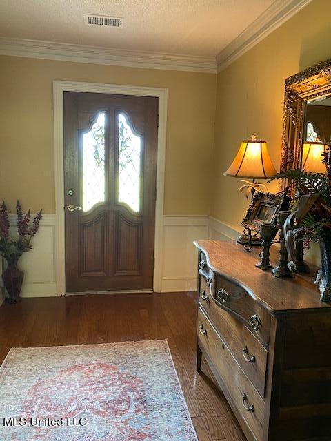 foyer entrance featuring crown molding, dark hardwood / wood-style floors, and a textured ceiling