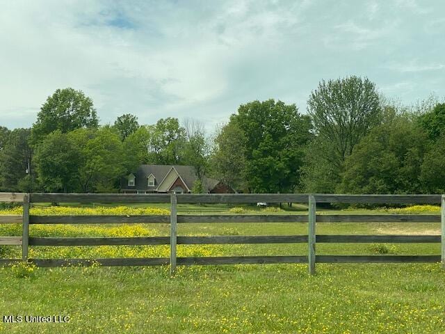 view of gate with a rural view and a yard