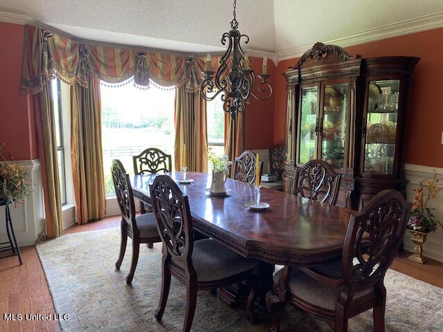 dining room featuring crown molding, a textured ceiling, and hardwood / wood-style flooring