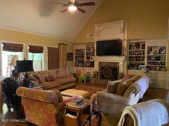 living room with ornamental molding, dark wood-type flooring, high vaulted ceiling, and ceiling fan