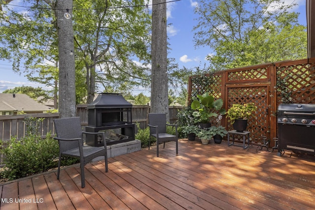 821 Planters Point Dr, Canton, MS 39046 - wooden deck with an outdoor fireplace, a grill, and a fenced backyard
