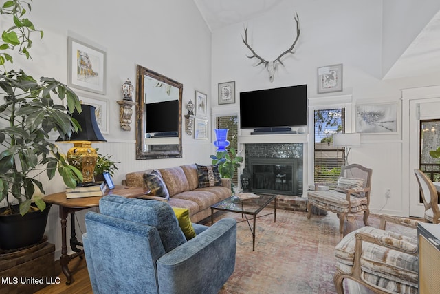 821 Planters Point Dr, Canton, MS 39046 - living room with high vaulted ceiling, a brick fireplace, a wainscoted wall, and wood finished floors