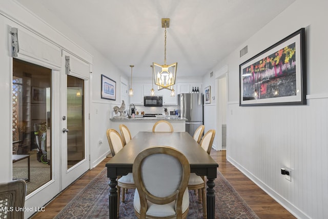 821 Planters Point Dr, Canton, MS 39046 - dining area with dark wood-style flooring, a chandelier, and french doors