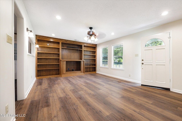 2185 Plum Point Rd, Southaven, MS 38672 - unfurnished living room with baseboards, dark wood-type flooring, recessed lighting, built in shelves, and a textured ceiling