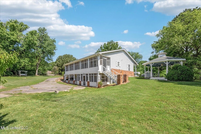 2185 Plum Point Rd, Southaven, MS 38672 - back of property with a sunroom, a gazebo, brick siding, and a lawn