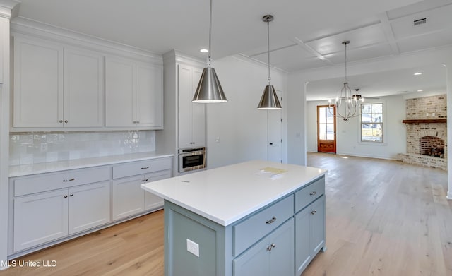 614 Cobalt Way, Brandon, MS 39042 - kitchen with decorative light fixtures, oven, backsplash, a center island, and light hardwood / wood-style flooring