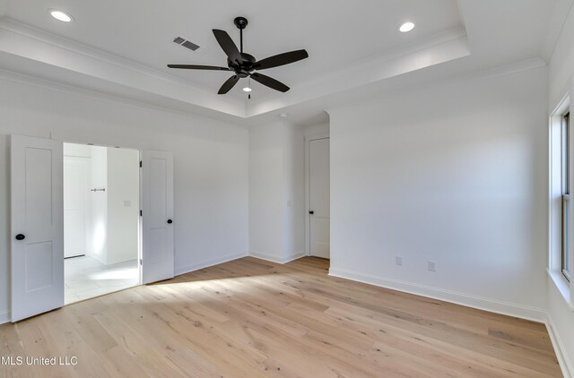 614 Cobalt Way, Brandon, MS 39042 - empty room with crown molding, ceiling fan, a tray ceiling, a healthy amount of sunlight, and light wood-type flooring
