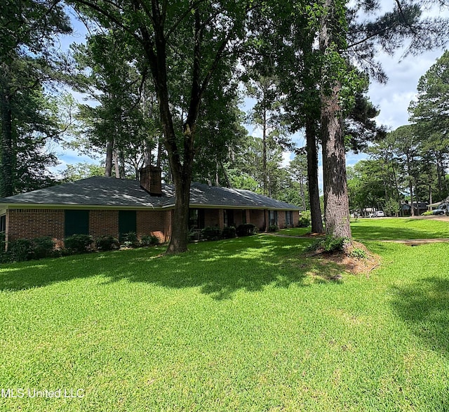 101 Dogwood Cir, Brandon, MS 39047 - view of front of home featuring a front yard, a chimney, and brick siding