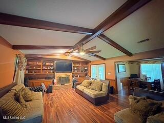 101 Dogwood Cir, Brandon, MS 39047 - living area featuring wood finished floors, a ceiling fan, and a fireplace with raised hearth
