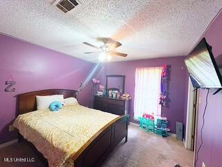 101 Dogwood Cir, Brandon, MS 39047 - bedroom with a textured ceiling, carpet floors, and ceiling fan