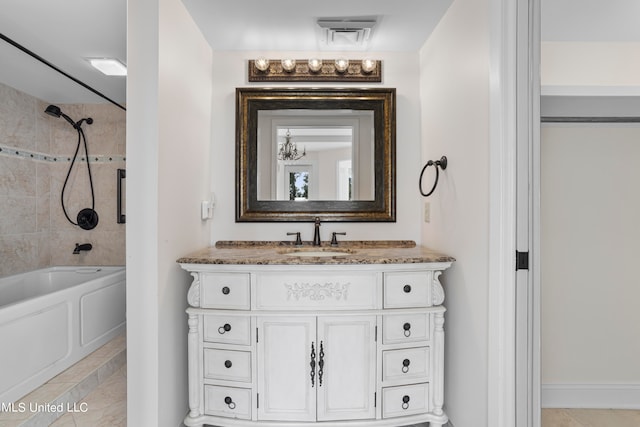 bathroom with vanity, tiled shower / bath combo, and tile patterned flooring