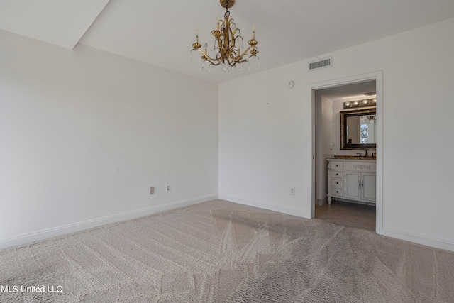 empty room featuring an inviting chandelier and light colored carpet