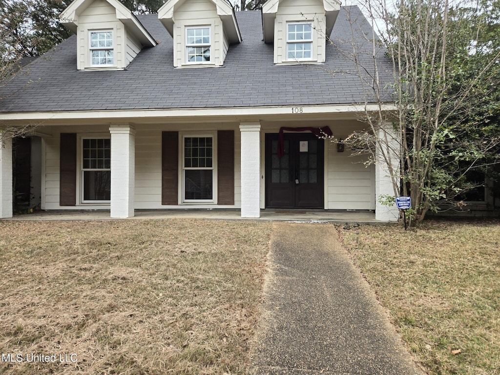 view of front facade with a front yard and covered porch