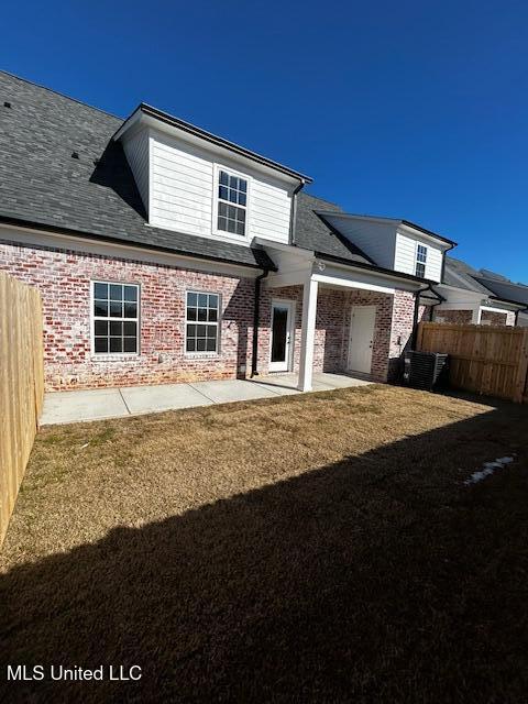 back of property featuring a lawn and a patio