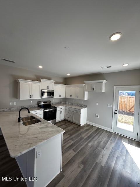 kitchen featuring white cabinets, kitchen peninsula, sink, and stainless steel appliances