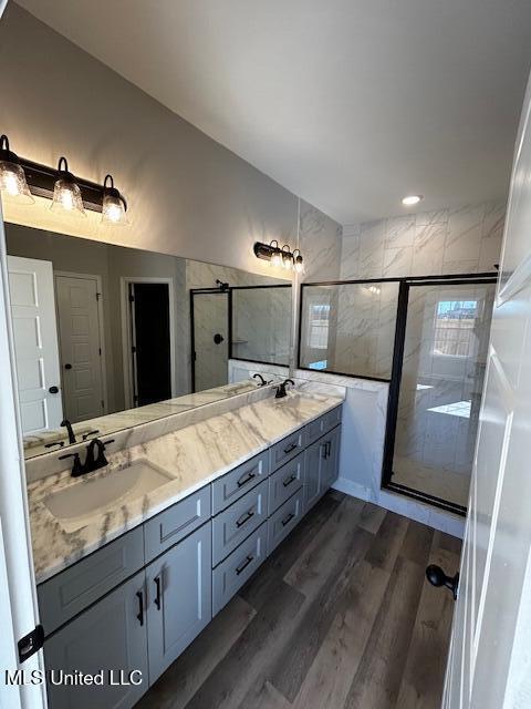 bathroom featuring hardwood / wood-style flooring, vanity, and an enclosed shower