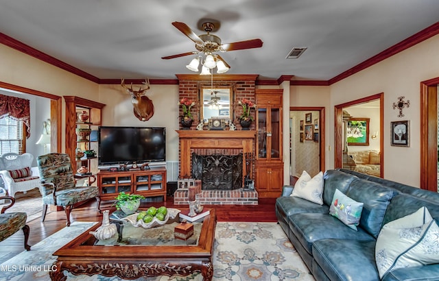 26 Woodgate Dr, Brandon, MS 39042 - living room with visible vents, crown molding, a brick fireplace, wood finished floors, and ceiling fan