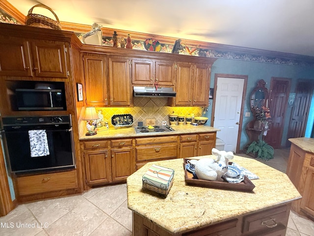 26 Woodgate Dr, Brandon, MS 39042 - kitchen with decorative backsplash, appliances with stainless steel finishes, brown cabinets, light tile patterned floors, and under cabinet range hood