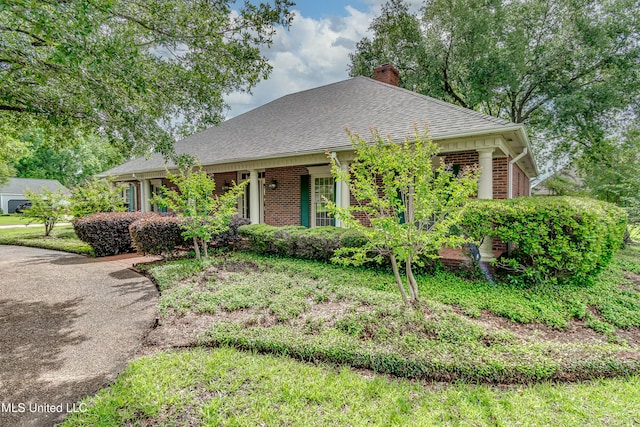 26 Woodgate Dr, Brandon, MS 39042 - view of front of home with brick siding, roof with shingles, and a chimney