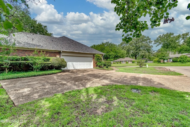 26 Woodgate Dr, Brandon, MS 39042 - view of home's exterior featuring a yard, a garage, brick siding, concrete driveway, and a shingled roof