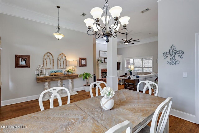 dining area featuring ceiling fan, crown molding, hardwood / wood-style floors, and a fireplace