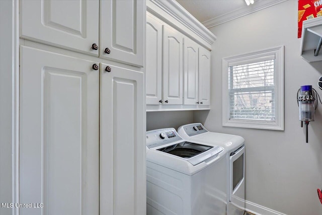 washroom with cabinets, washing machine and dryer, and crown molding