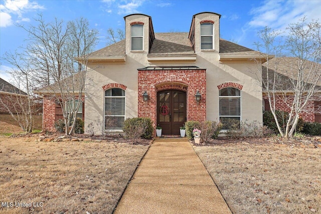 french country style house with french doors and a front lawn