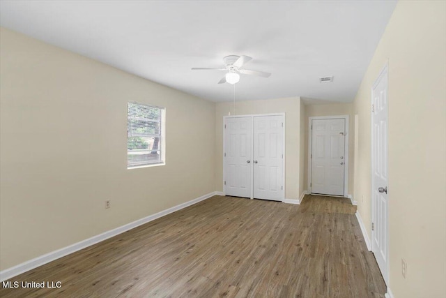 unfurnished bedroom featuring ceiling fan, a closet, and light wood-type flooring