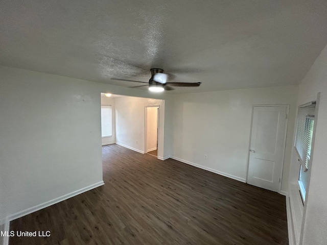 spare room featuring a textured ceiling, dark wood-type flooring, and ceiling fan