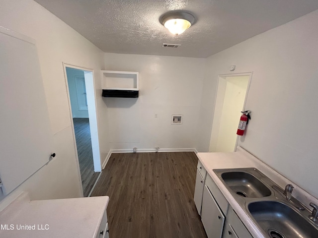 washroom with sink, washer hookup, a textured ceiling, and dark hardwood / wood-style flooring