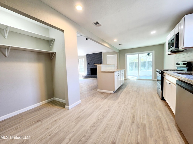 kitchen with stainless steel appliances, light wood-style floors, visible vents, and white cabinets