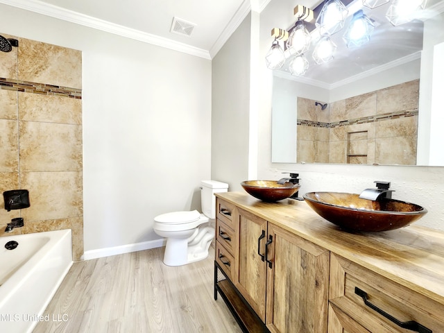 bathroom with visible vents, toilet, ornamental molding, a sink, and wood finished floors