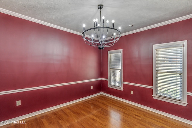 spare room featuring hardwood / wood-style flooring, ornamental molding, a chandelier, and a textured ceiling