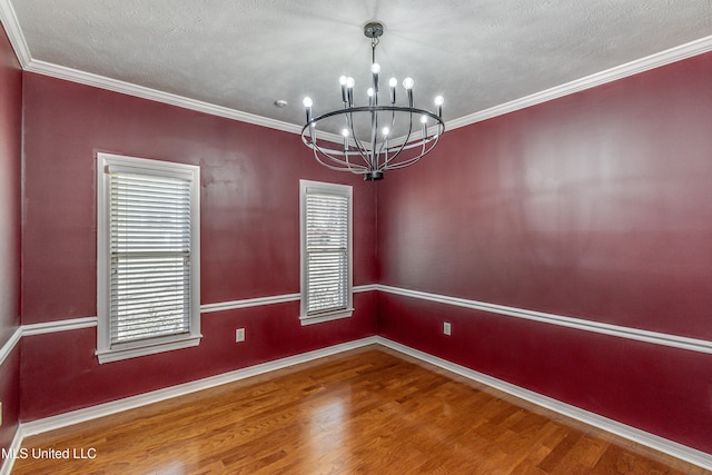 empty room with hardwood / wood-style flooring, crown molding, a notable chandelier, and a textured ceiling