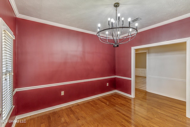 unfurnished dining area featuring crown molding, a notable chandelier, hardwood / wood-style flooring, and a textured ceiling