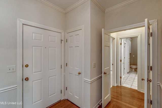 hallway with hardwood / wood-style flooring and crown molding