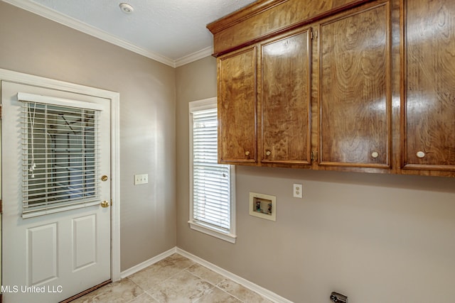 washroom featuring hookup for a washing machine, a wealth of natural light, ornamental molding, and cabinets