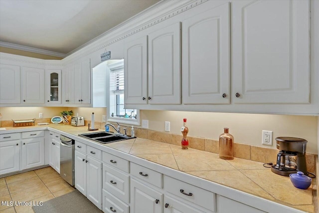 kitchen featuring dishwasher, sink, light tile patterned floors, white cabinets, and ornamental molding