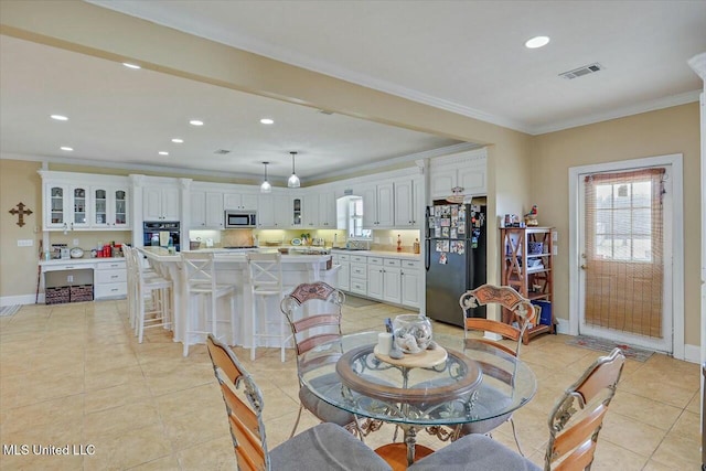 tiled dining space with sink and ornamental molding