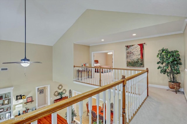 hall featuring carpet floors, high vaulted ceiling, and crown molding