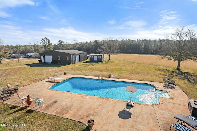 view of pool with an outbuilding, a yard, a patio, and a diving board