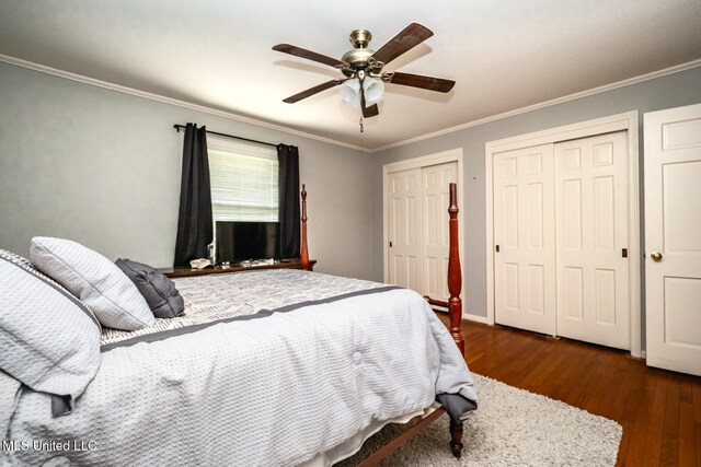 bedroom with crown molding, multiple closets, ceiling fan, and wood finished floors