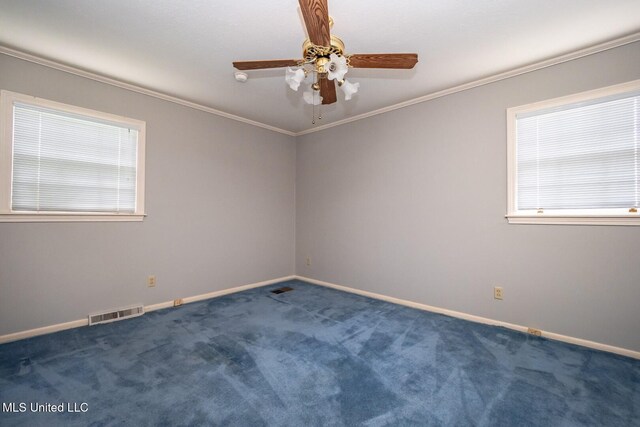 empty room featuring carpet flooring, crown molding, ceiling fan, baseboards, and visible vents