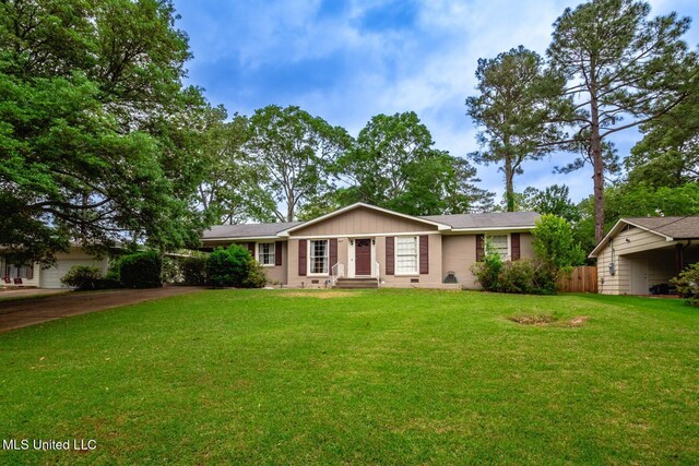 ranch-style house featuring a front yard and concrete driveway