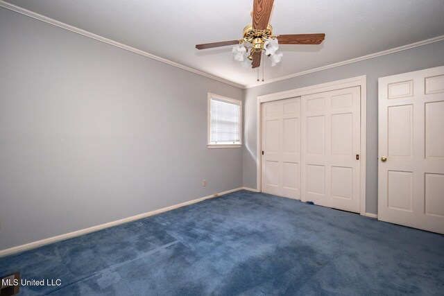 unfurnished bedroom with crown molding, carpet floors, a closet, baseboards, and a ceiling fan