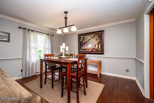 dining room with crown molding, baseboards, and wood finished floors