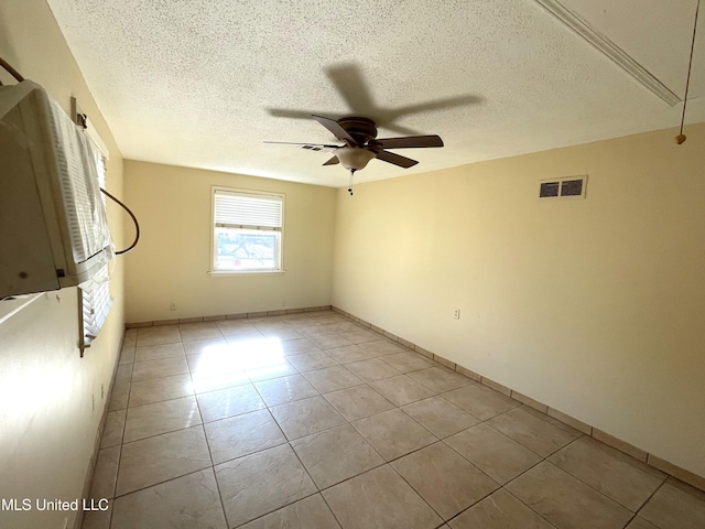 spare room with ceiling fan, a textured ceiling, and light tile patterned floors