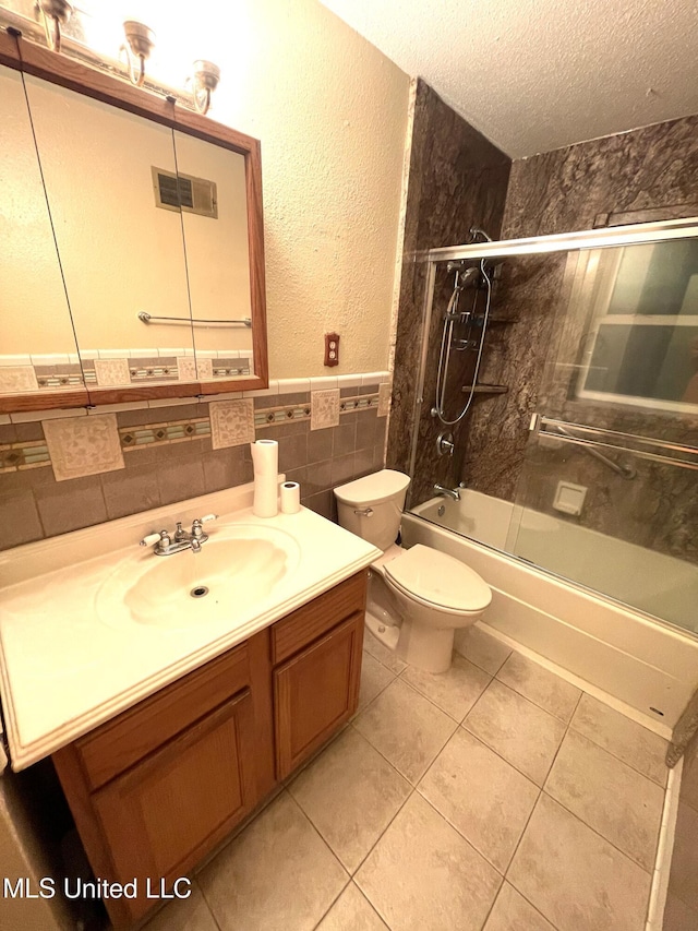 full bathroom featuring a textured ceiling, shower / bath combination with glass door, tile walls, tile patterned flooring, and toilet