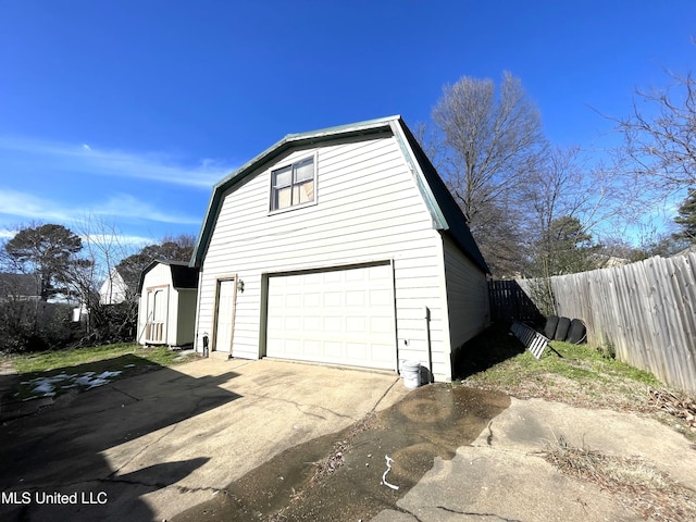 view of home's exterior with a garage and a storage unit