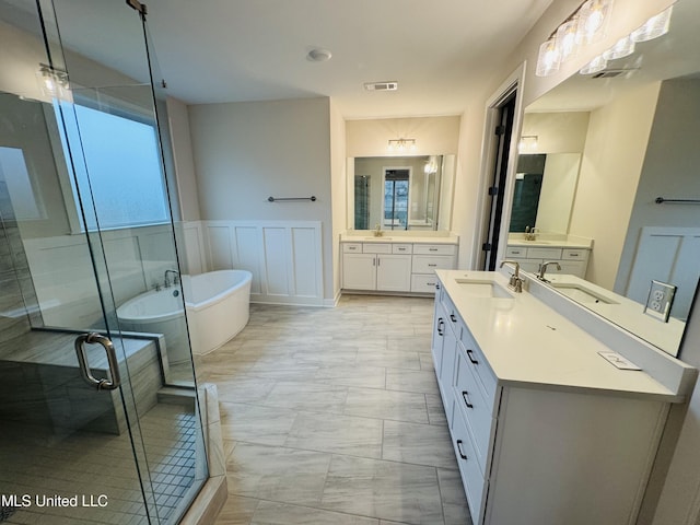 full bath featuring marble finish floors, plenty of natural light, a stall shower, and a soaking tub